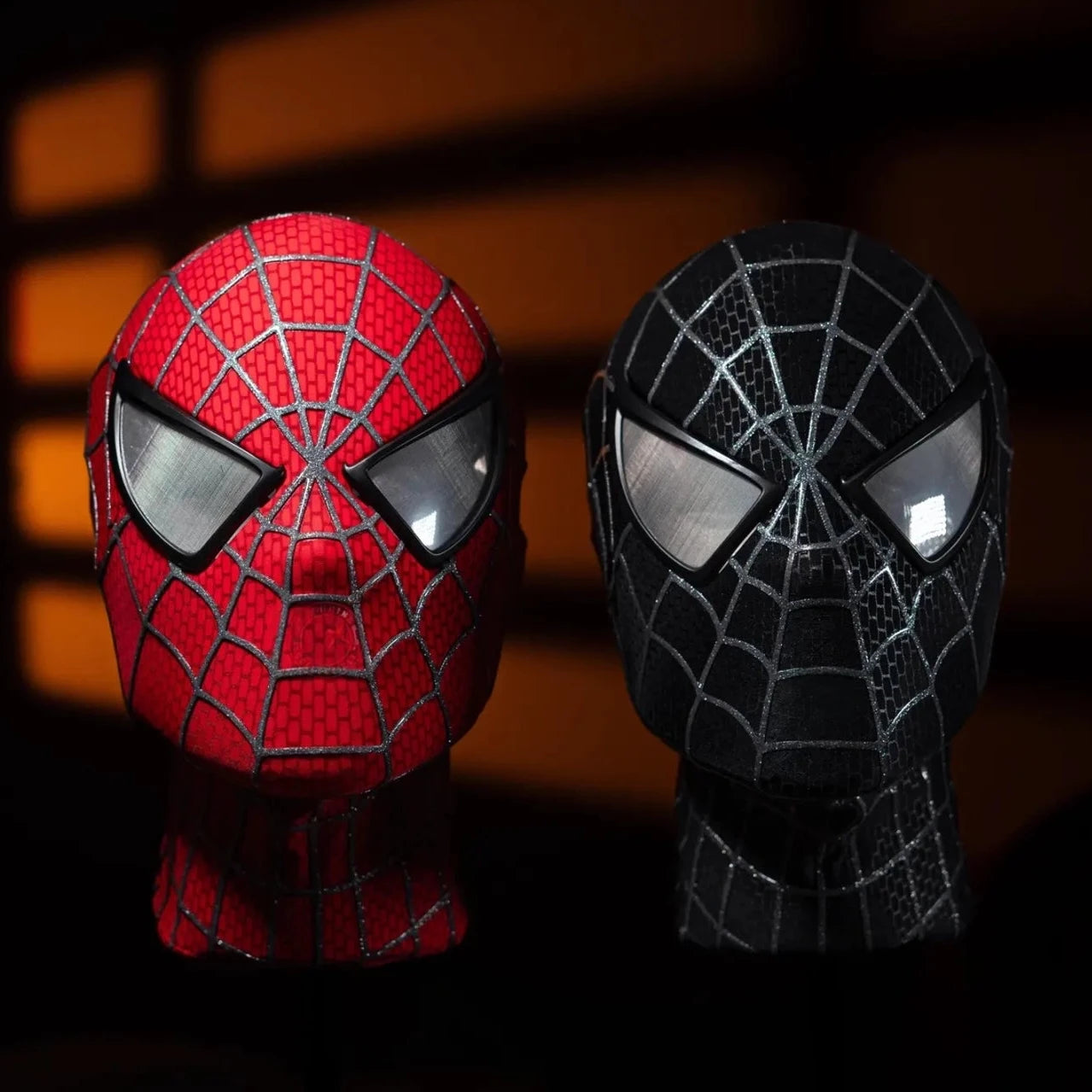 Red and black superhero masks with spider web patterns on a dark background