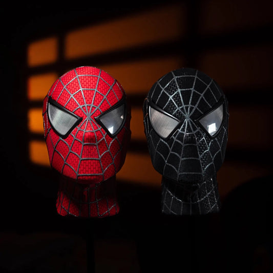 Red and black superhero masks with spider web patterns on a dark background